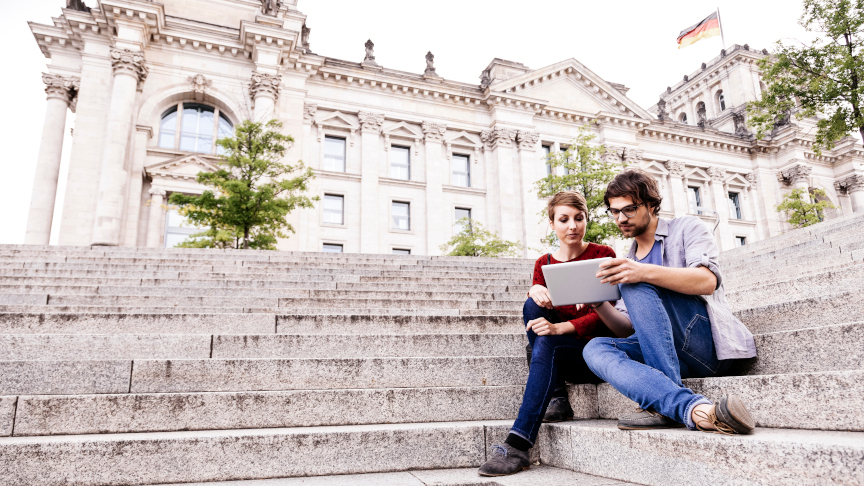 Studierende mit Tablet PC auf den Stufen des Berliner Reichstags.